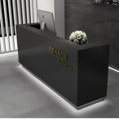 a black and white reception desk with flowers on it