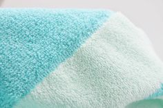 a blue and white towel sitting on top of a bed