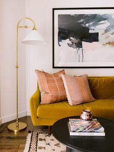 a living room filled with furniture and a painting on the wall