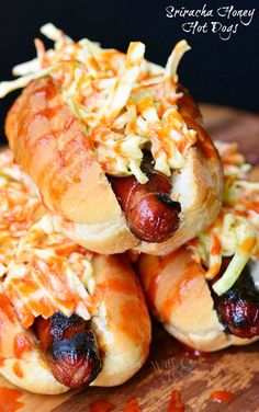 two hotdogs covered in coleslaw and cheese on top of each other