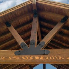 the underside of a wooden roof with metal brackets on it's sides and an opening at the top