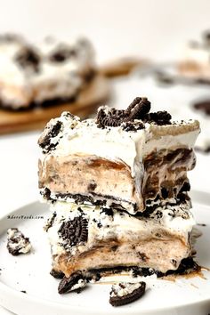 three pieces of ice cream and oreo cookie dessert on a white plate with cookies