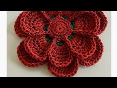 a crocheted red flower with green center