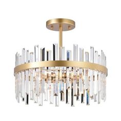 a gold chandelier with clear crystal drops hanging from the ceiling and an oval light fixture