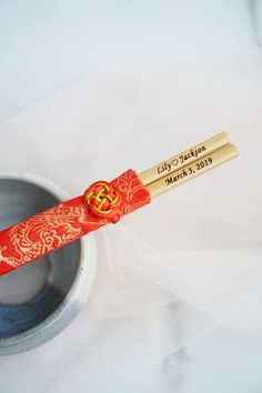 a red and gold toothbrush sitting on top of a cup