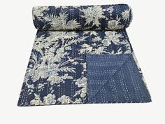 a blue and white floral print quilted blanket