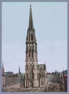 an old photo of a very tall building in the middle of a city with lots of people around it