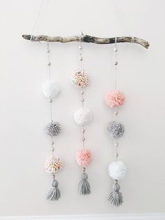 a wall hanging with pom poms and beads