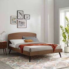 a bed sitting on top of a wooden frame in a bedroom