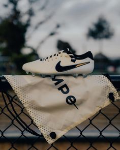 a pair of nike shoes sitting on top of a fence