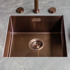 a stainless steel kitchen sink with two faucets on the side and an overflowing drain