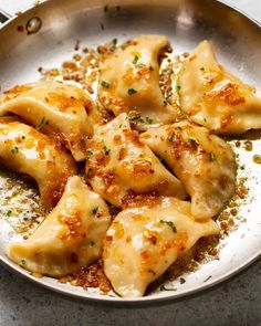 a pan filled with dumplings covered in sauce