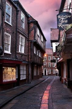 an alley way with old buildings on both sides and a sign that says the real tea rooms