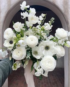 a white vase filled with lots of white flowers