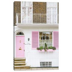 a pink door and window in front of a white house