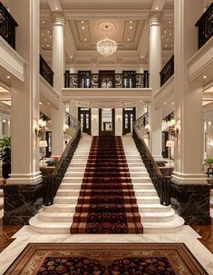 a large staircase in the middle of a building with chandeliers on either side