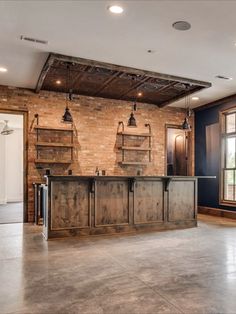 an industrial style bar in the middle of a room with brick walls and exposed ceilings