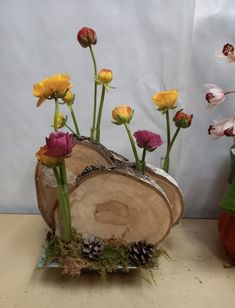 two vases with flowers in them sitting on a table next to another vase filled with flowers