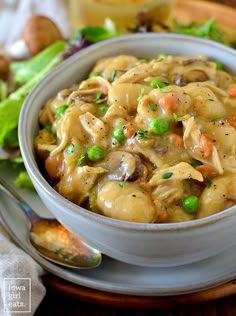 a bowl filled with pasta and peas on top of a table