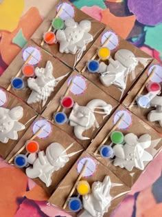 some cupcakes are decorated with white icing and colorful candies on brown paper