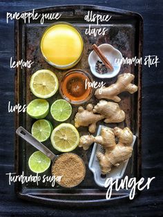 the ingredients for ginger tea are arranged on a tray, including lemons, ginger and ginger