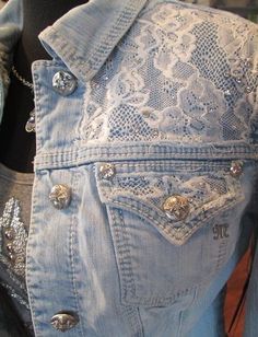 a denim jacket with buttons and lace on it