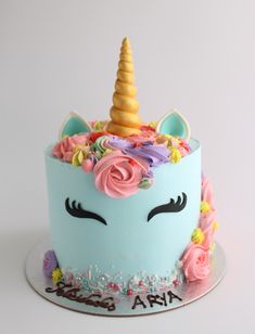 a birthday cake decorated with an unicorn's face and flowers