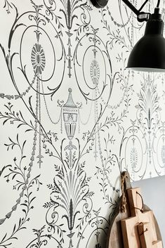 the wallpaper is black and white with an intricate design on it, along with a wooden block