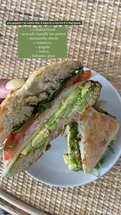 a sandwich with avocado and tomato on it is being held up by someone's hand