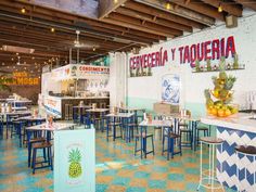 the inside of a restaurant with blue and yellow tables, stools and counter tops