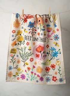 a tea towel hanging on a clothes line with bees love thee printed on the front