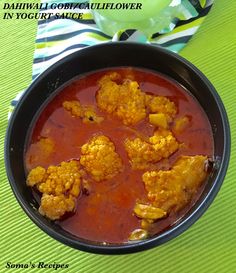 a bowl filled with meat and sauce on top of a table