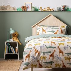 a child's bedroom with green walls and giraffe bedding