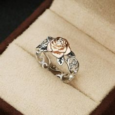 a ring with a rose on it in a box