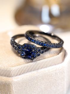 two wedding rings with blue sapphire stones on top