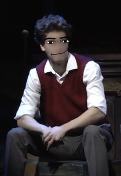 a young man sitting on top of a wooden chair