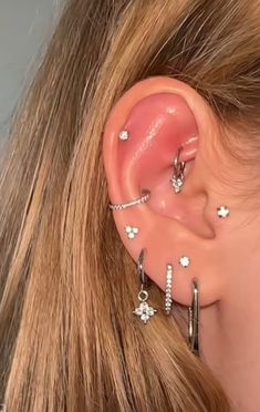 a close up of a person with ear piercings on their ears and behind the ear