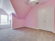 an empty room with pink walls and carpet