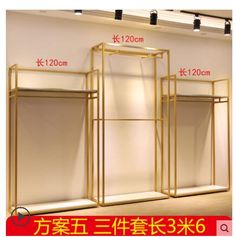 an image of a store display with gold metal racks and lights on the wall in front of it