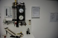 a clock mounted to the side of a white wall next to some papers and other items