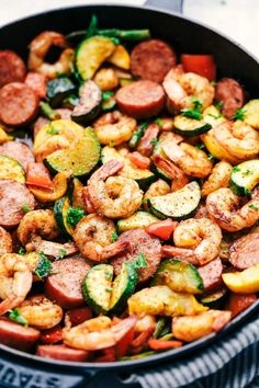 a skillet filled with shrimp, zucchini and other vegtables