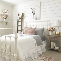 a white bed sitting next to a wooden table