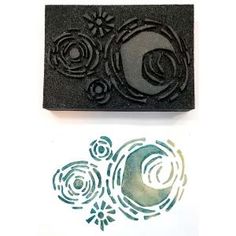 two rubber stamps with flowers and swirls on them, one has the letter c