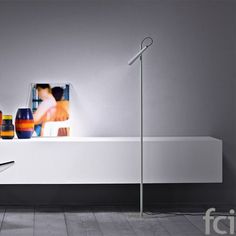 a white shelf with pictures on it next to a lamp