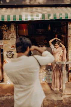 a woman standing in front of a store with her hands on her head and looking into the window