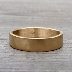 a gold wedding ring sitting on top of a wooden table