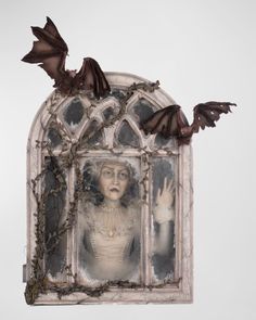 an image of a woman in a window with bats on her head and hands out