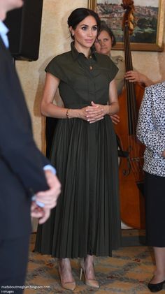 a woman in a green dress standing next to a man