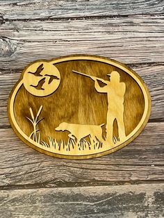 a wooden plaque depicting a man shooting a dog