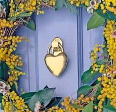 a blue door with yellow flowers and a gold heart